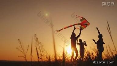 快乐的家庭在日落时玩风筝。妈妈, 爸爸和女儿在一起很开心。